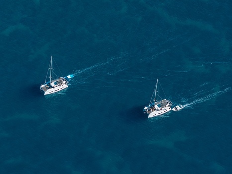 Aerial view of two catamarans sailing in the deep blue Mediterranean Sea near the coast of Le Trayas in Saint Raphael Provence Alpes Cote d Azur France. Aerial view of two catamarans sailing in the deep blue Mediterranean Sea near the coast of Le Trayas in Saint Raphael Provence Alpes Cote d Azur France.