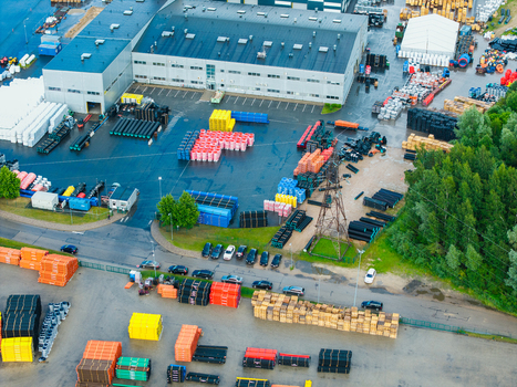 Jelgava Latvia 04 July 2026 Aerial view of an industrial facility for polymer pipe manufacturing featuring large warehouses stacks of colorful pipes and a parking area.