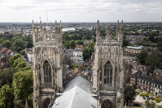 Aerial view of the historic York Minster towers rising above the surrounding urban landscape and lush greenery in York England United Kingdom.