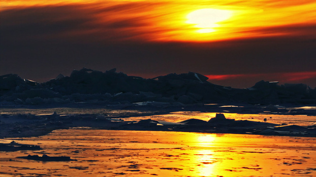 Aerial view of frozen ice landscape reflecting a vibrant sunset in Latvia. Aerial view of frozen ice landscape reflecting a vibrant sunset in Latvia.