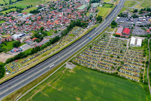 Geiselwind Germany 20 June 2025 Aerial view of Heroes Festival Geiselwind featuring massive parking lots filled with cars next to the A3 motorway and the town rooftops.
