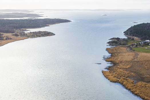 Aerial view of Nordre alv river flowing through the landscape with reeds forest and coastal scenery in Vastra Gotaland County Sweden.