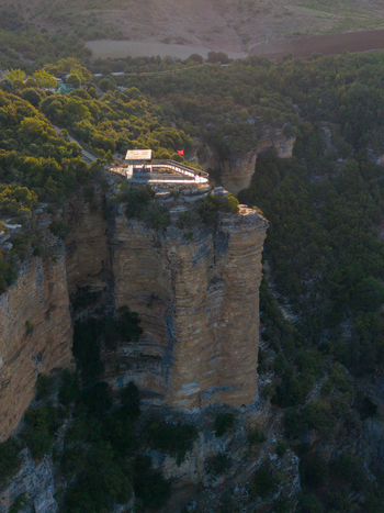 Aerial view of Osumi canyon featuring a cliffside observation deck surrounded by lush green vegetation and rugged rock formations in Dhores Berat County Albania.