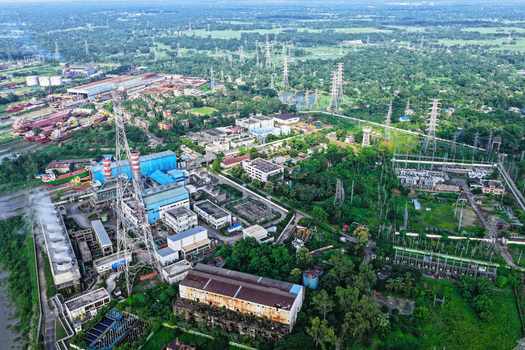 Aerial view of the Karnaphuli River power plant featuring industrial buildings cooling towers and transmission lines in lush surroundings in Chattogram Chittagong Division Bangladesh.