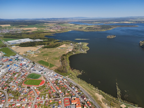 Aerial view of Oravska priehrada reservoir and the town of Namestovo with its residential houses and sports stadium under a clear blue sky Namestovo Zilinsky kraj Slovakia. Aerial view of Oravska priehrada reservoir and the town of Namestovo with its residential houses and sports stadium under a clear blue sky Namestovo Zilinsky kraj Slovakia.