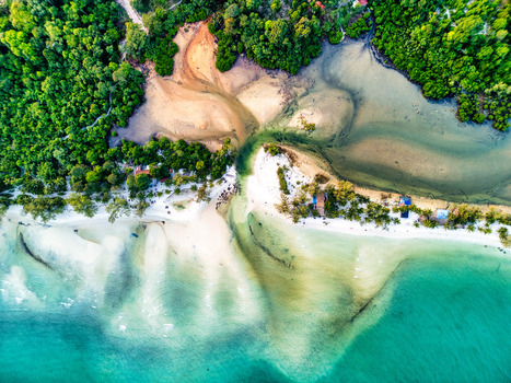 Aerial view of the shoreline where turquoise waters meet the sandy beach and lush greenery Preah Sihanouk Sihanoukville Cambodia.