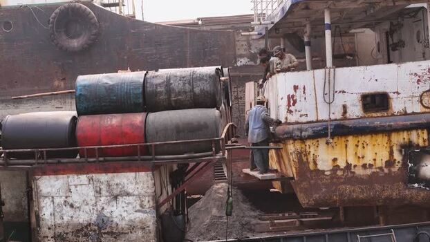 Aerial view of workers on a ship with barrels in Dhaka Bangladesh. Aerial view of workers on a ship with barrels in Dhaka Bangladesh.