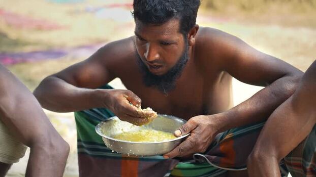 View of a man eating a traditional meal from a bowl Bangladesh. View of a man eating a traditional meal from a bowl Bangladesh.