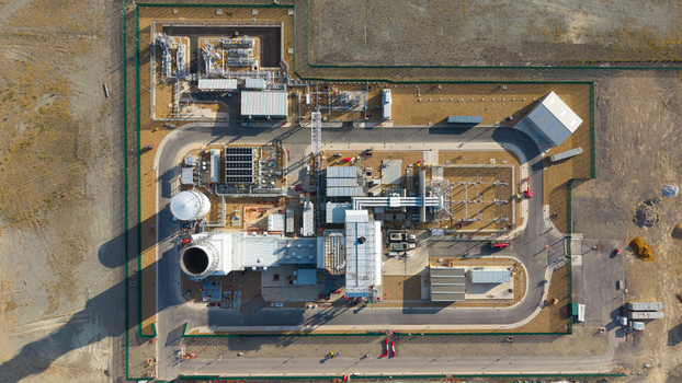 Aerial view of Millbrook Power Plant featuring industrial infrastructure storage tanks power units and paved roads within a fenced facility in Stewartby England United Kingdom. Aerial view of Millbrook Power Plant featuring industrial infrastructure storage tanks power units and paved roads within a fenced facility in Stewartby England United Kingdom.