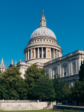 London United Kingdom 19 June 2025 View of St. Paul s Cathedral bathed in sunlight its grand dome piercing the azure sky surrounded by lush greenery. London United Kingdom 19 June 2025 View of St. Paul s Cathedral bathed in sunlight its grand dome piercing the azure sky surrounded by lush greenery.