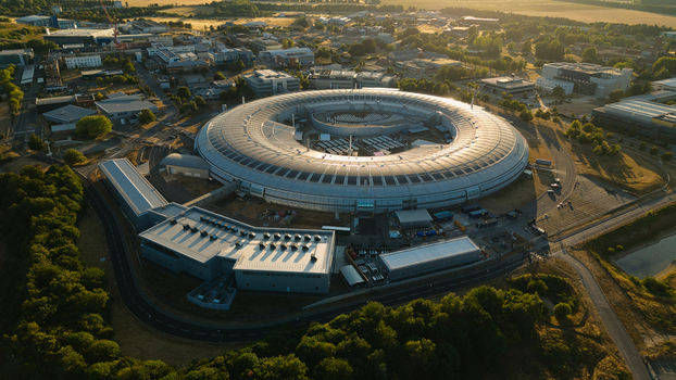 Aerial view of Diamond Light Source a circular synchrotron facility surrounded by greenery under golden hour light in Didcot United Kingdom.