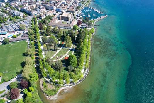 Aerial view of Morges Castle and Parc de l Independance along the shores of Lake Geneva with clear turquoise water and a small harbor Morges Vaud Switzerland. Aerial view of Morges Castle and Parc de l Independance along the shores of Lake Geneva with clear turquoise water and a small harbor Morges Vaud Switzerland.