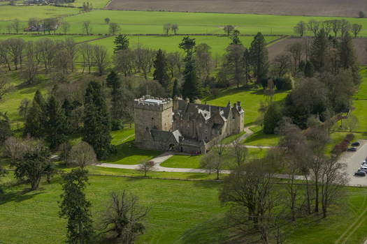 Aerial view of Drum Castle Garden and Estate National Trust for Scotland featuring the historic stone tower and lush green lawns in Drumoak Scotland United Kingdom.