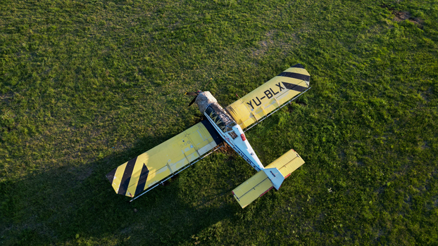 Serbia 03 September 2023 Aerial view of a yellow agricultural aircraft parked on a grassy field.