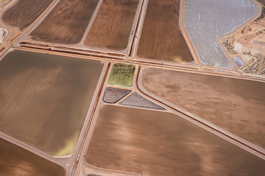 Aerial view of industrial salt evaporation ponds showing geometric patterns in shades of brown yellow and white after a storm in Kalbarri Western Australia Australia. Aerial view of industrial salt evaporation ponds showing geometric patterns in shades of brown yellow and white after a storm in Kalbarri Western Australia Australia.