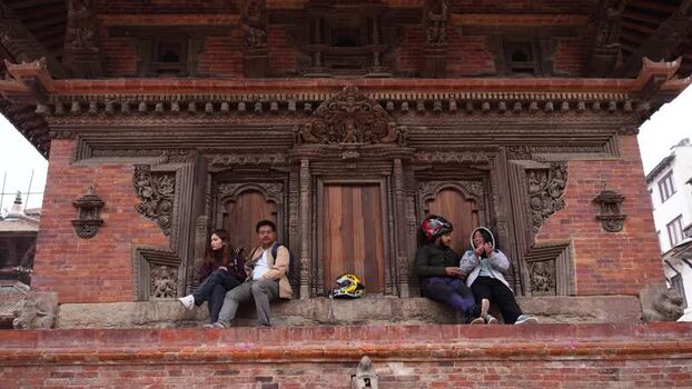 View of people sitting by a traditional temple in Kathmandu Nepal.
