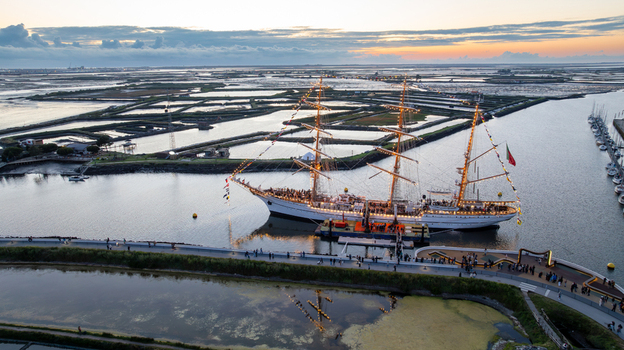 Aerial view of the tall ship NRP Sagres decorated with signal flags navigating the Canal de Aveiro near the salt pans Aveiro Aveiro Portugal. Aerial view of the tall ship NRP Sagres decorated with signal flags navigating the Canal de Aveiro near the salt pans Aveiro Aveiro Portugal.
