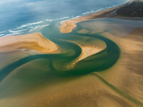 Aerial view of serpentine waters snaking through the golden sands where the ocean s edge meets the land in a dance of blue and beige Rauðisandur Iceland. Aerial view of serpentine waters snaking through the golden sands where the ocean s edge meets the land in a dance of blue and beige Rauðisandur Iceland.