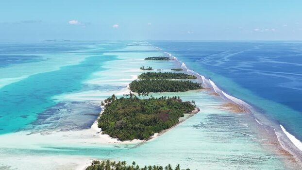 Aerial view of tropical islands and turquoise lagoons in Maldives.