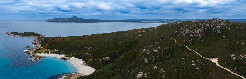 Aerial view of Bettys Beach with turquoise water white sand rocky coastline and coastal vegetation under a cloudy sky in Albany WA Australia. Aerial view of Bettys Beach with turquoise water white sand rocky coastline and coastal vegetation under a cloudy sky in Albany WA Australia.