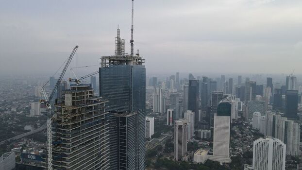 Kecamatan Menteng Indonesia 03 December 2021 Aerial view of Jakarta Pusat skyline featuring skyscrapers under construction with tower cranes glass facades and urban density. Kecamatan Menteng Indonesia 03 December 2021 Aerial view of Jakarta Pusat skyline featuring skyscrapers under construction with tower cranes glass facades and urban density.