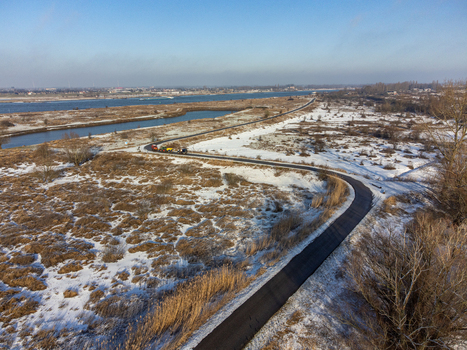 Aerial view of a winding path cutting through the snow dusted marshlands near Vlietberg under a clear sky Tiengeboden Gelderland Netherlands. Aerial view of a winding path cutting through the snow dusted marshlands near Vlietberg under a clear sky Tiengeboden Gelderland Netherlands.
