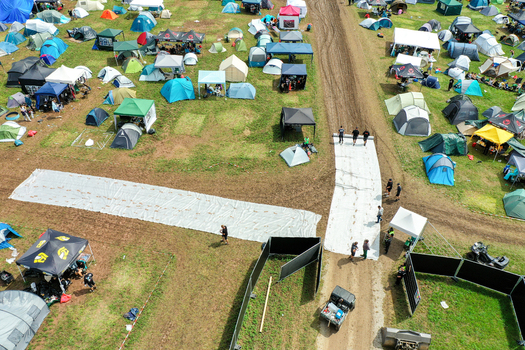 Herzogenaurach Germany 27 July 2025 Aerial view of the Open Beatz Festival campsite featuring colorful tents people walking on white plastic paths and muddy ground. Herzogenaurach Germany 27 July 2025 Aerial view of the Open Beatz Festival campsite featuring colorful tents people walking on white plastic paths and muddy ground.