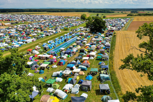 Herzogenaurach Germany 24 July 2025 Aerial view of the Open Beatz Festival campsite with thousands of colorful tents spread across green fields under a summer sky.