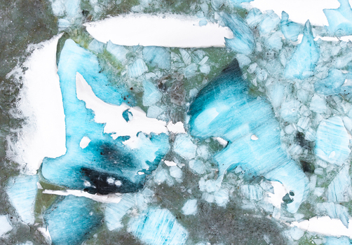 Aerial view of a mosaic of ice and snow fractured with turquoise hues paints a stark brittle landscape &Ouml;r&aelig;fi Iceland.