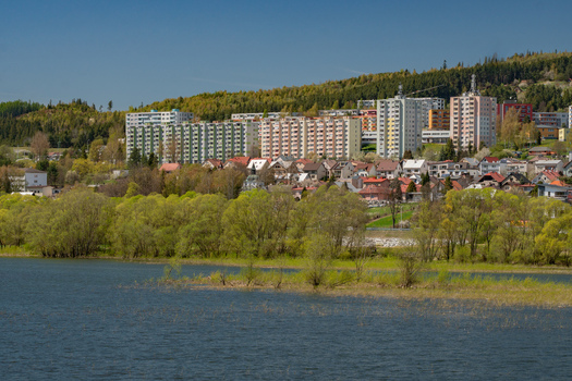 Aerial view of Namestovo town and Oravska priehrada dam featuring residential apartment blocks houses lush green trees and the calm reservoir water in Namestovo Zilina Region Slovakia. Aerial view of Namestovo town and Oravska priehrada dam featuring residential apartment blocks houses lush green trees and the calm reservoir water in Namestovo Zilina Region Slovakia.