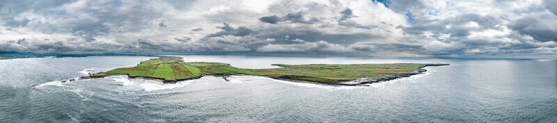 Aerial view of St John s Point Beach featuring green fields rocky coastline and dramatic clouds over the Atlantic Ocean in Dunkineely County Donegal Ireland.