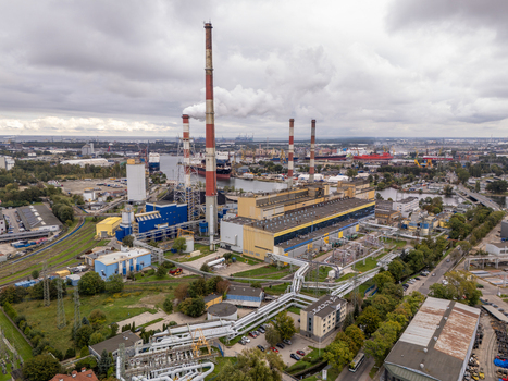 Gdansk Poland 24 September 2026 Aerial view of a large industrial power plant with tall chimneys emitting smoke surrounded by pipes and infrastructure near the port under a cloudy sky.