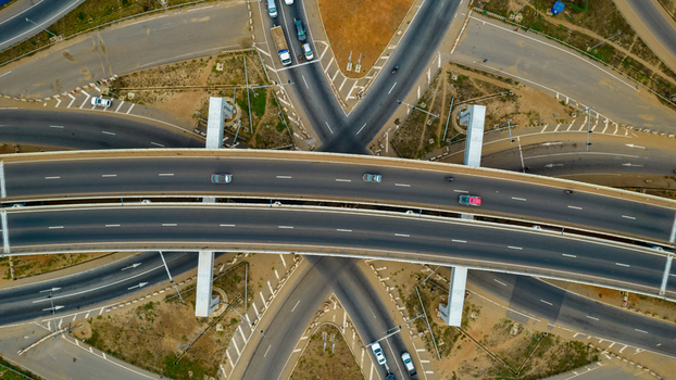 Aerial view of the Tema Motorway interchange featuring multi level flyovers and connecting roads with vehicles moving through the junction in Accra Greater Accra Region Ghana. Aerial view of the Tema Motorway interchange featuring multi level flyovers and connecting roads with vehicles moving through the junction in Accra Greater Accra Region Ghana.