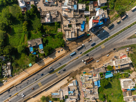 Aerial view of a busy highway with vehicles traveling through the urban landscape of Udaipur Rajasthan India. Aerial view of a busy highway with vehicles traveling through the urban landscape of Udaipur Rajasthan India.