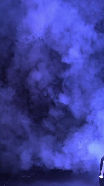 View of thick blue smoke rising against a dark background.