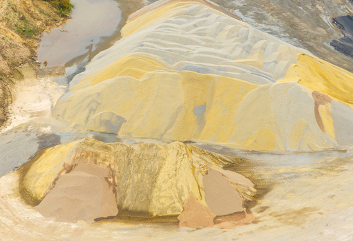 Aerial view of large piles of sand and gravel at an asphalt mixing plant near an expressway in Pomeranian Voivodeship Poland.