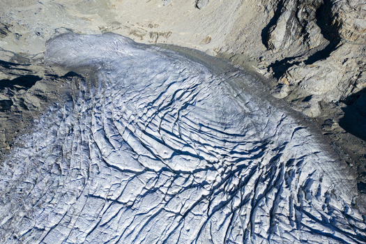 Aerial view of the Morteratsch Glacier s icy expanse a symphony of glacial blues and greys etched across the landscape Morteratsch Glacier Grisons Switzerland. Aerial view of the Morteratsch Glacier s icy expanse a symphony of glacial blues and greys etched across the landscape Morteratsch Glacier Grisons Switzerland.