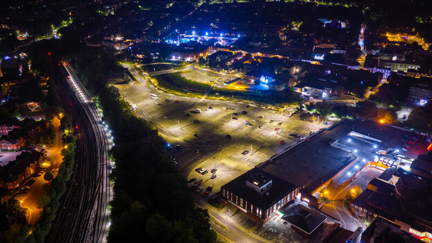 Aerial view of the city of Salisbury at night featuring illuminated parking lots railway tracks and urban buildings in Salisbury England United Kingdom. Aerial view of the city of Salisbury at night featuring illuminated parking lots railway tracks and urban buildings in Salisbury England United Kingdom.
