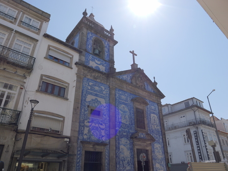 View of the Capela das Almas in Porto featuring its iconic blue and white azulejo tiled facade under a bright sunny sky in Porto Porto District Portugal. View of the Capela das Almas in Porto featuring its iconic blue and white azulejo tiled facade under a bright sunny sky in Porto Porto District Portugal.
