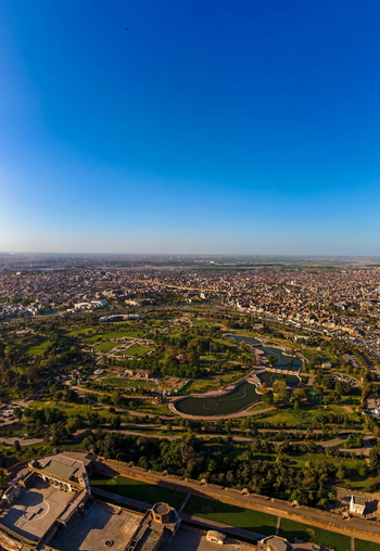 Aerial view of Minar e Pakistan and the surrounding Greater Iqbal Park with its lush green lawns and water features set against the sprawling urban landscape of Lahore Punjab Pakistan.