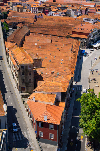 Aerial view of terracotta rooftops cascading down a tapestry of aged tiles and sun drenched surfaces nestled alongside the Douro River Porto Porto District Portugal. Aerial view of terracotta rooftops cascading down a tapestry of aged tiles and sun drenched surfaces nestled alongside the Douro River Porto Porto District Portugal.