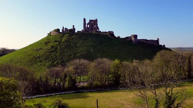 Aerial view of Corfe Castle ruins on a green hill United Kingdom.