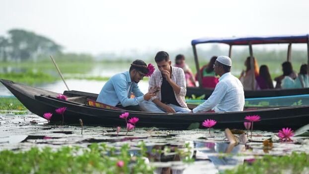View of people in a boat on a water lily pond Bangladesh. View of people in a boat on a water lily pond Bangladesh.