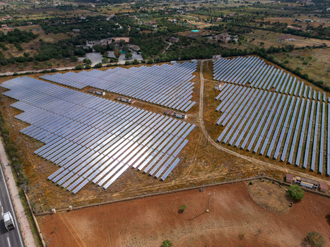 Aerial view of a large solar panel farm with rows of photovoltaic modules surrounded by rural fields and green trees in Manacor Balearic Islands Spain. Aerial view of a large solar panel farm with rows of photovoltaic modules surrounded by rural fields and green trees in Manacor Balearic Islands Spain.
