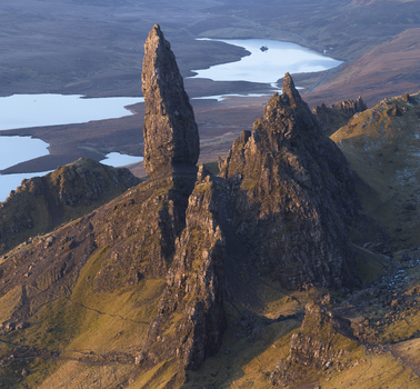 Aerial view of The Storr rock pinnacles and the Old Man of Storr overlooking the calm waters of Loch Leathan Isle of Skye Scotland United Kingdom. Aerial view of The Storr rock pinnacles and the Old Man of Storr overlooking the calm waters of Loch Leathan Isle of Skye Scotland United Kingdom.