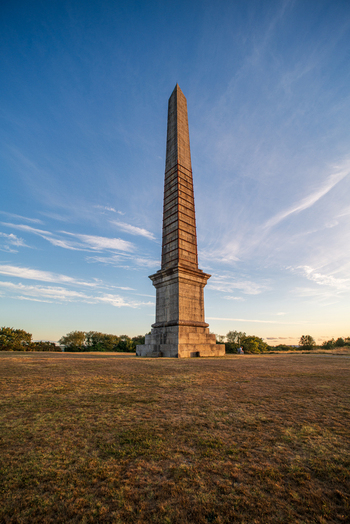 View of the historic Bodmin Beacon obelisk standing tall in a grassy field under a clear blue sky during golden hour in Bodmin Cornwall United Kingdom. View of the historic Bodmin Beacon obelisk standing tall in a grassy field under a clear blue sky during golden hour in Bodmin Cornwall United Kingdom.