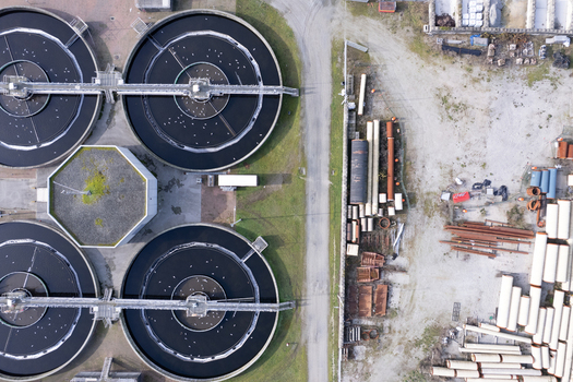 Aerial view of the wastewater treatment plant with circular sedimentation tanks industrial pipes and storage areas in Richmond British Columbia Canada. Aerial view of the wastewater treatment plant with circular sedimentation tanks industrial pipes and storage areas in Richmond British Columbia Canada.