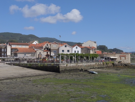 View of the historic coastal village with traditional stone houses terracotta rooftops and a waterfront promenade at low tide Combarro Pontevedra Spain.