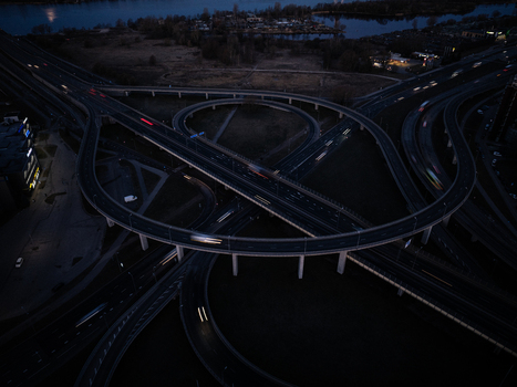 Aerial view of the Salu Bridge and Krasta Street interchange at night with light trails from moving vehicles and the Daugava River in the background in Riga Latvia. Aerial view of the Salu Bridge and Krasta Street interchange at night with light trails from moving vehicles and the Daugava River in the background in Riga Latvia.
