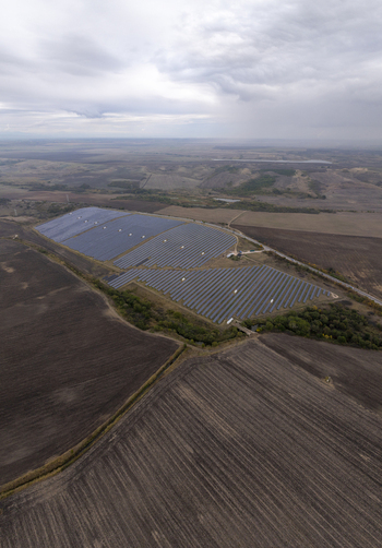 Aerial view of a large solar farm situated in a rural landscape with plowed fields and a cloudy sky in Bulgaria. Aerial view of a large solar farm situated in a rural landscape with plowed fields and a cloudy sky in Bulgaria.
